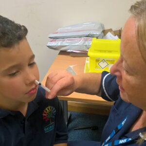 Children receive a free nasal flu spray vaccine